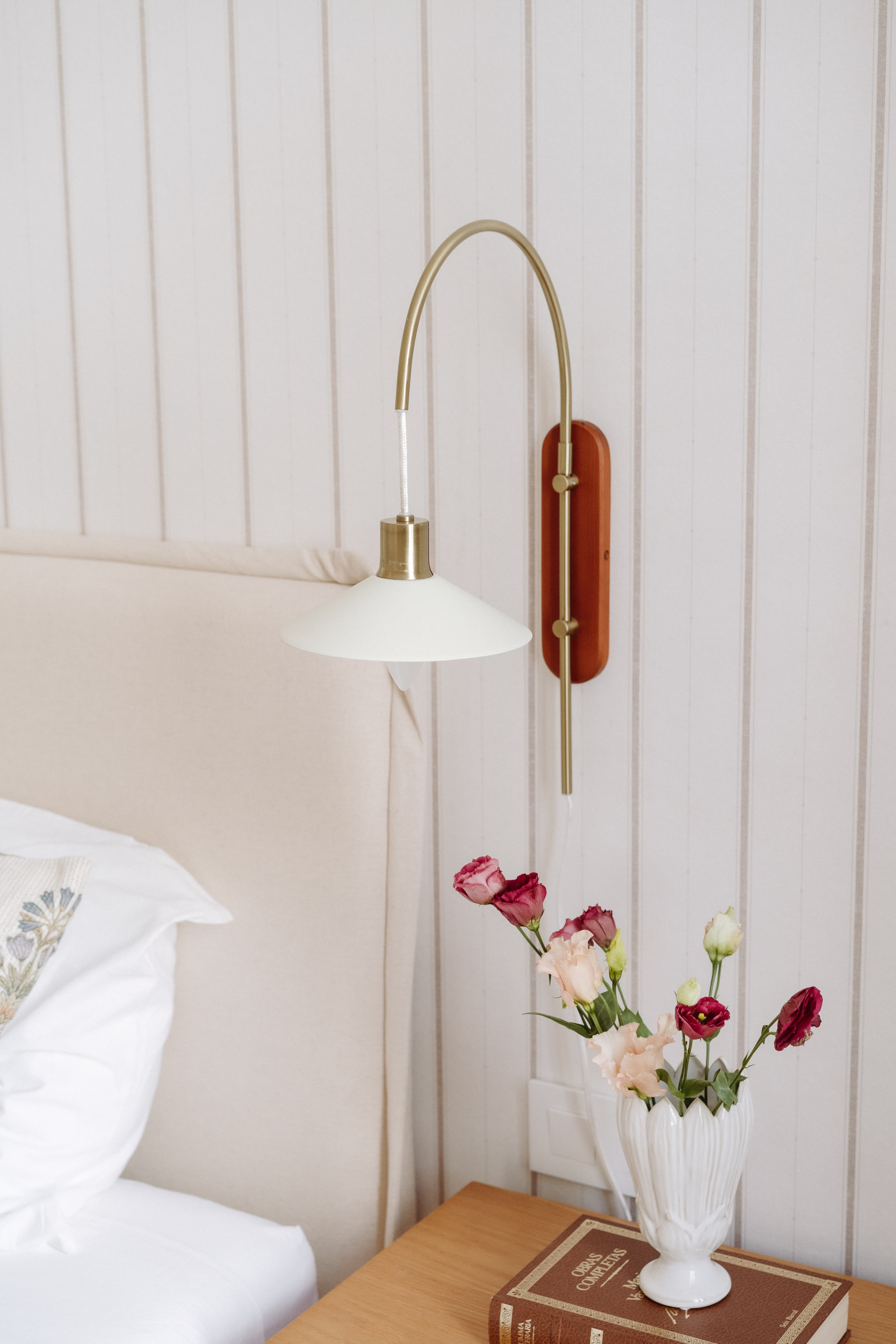 Detalle del aplique dorado junto al cabecero de la cama