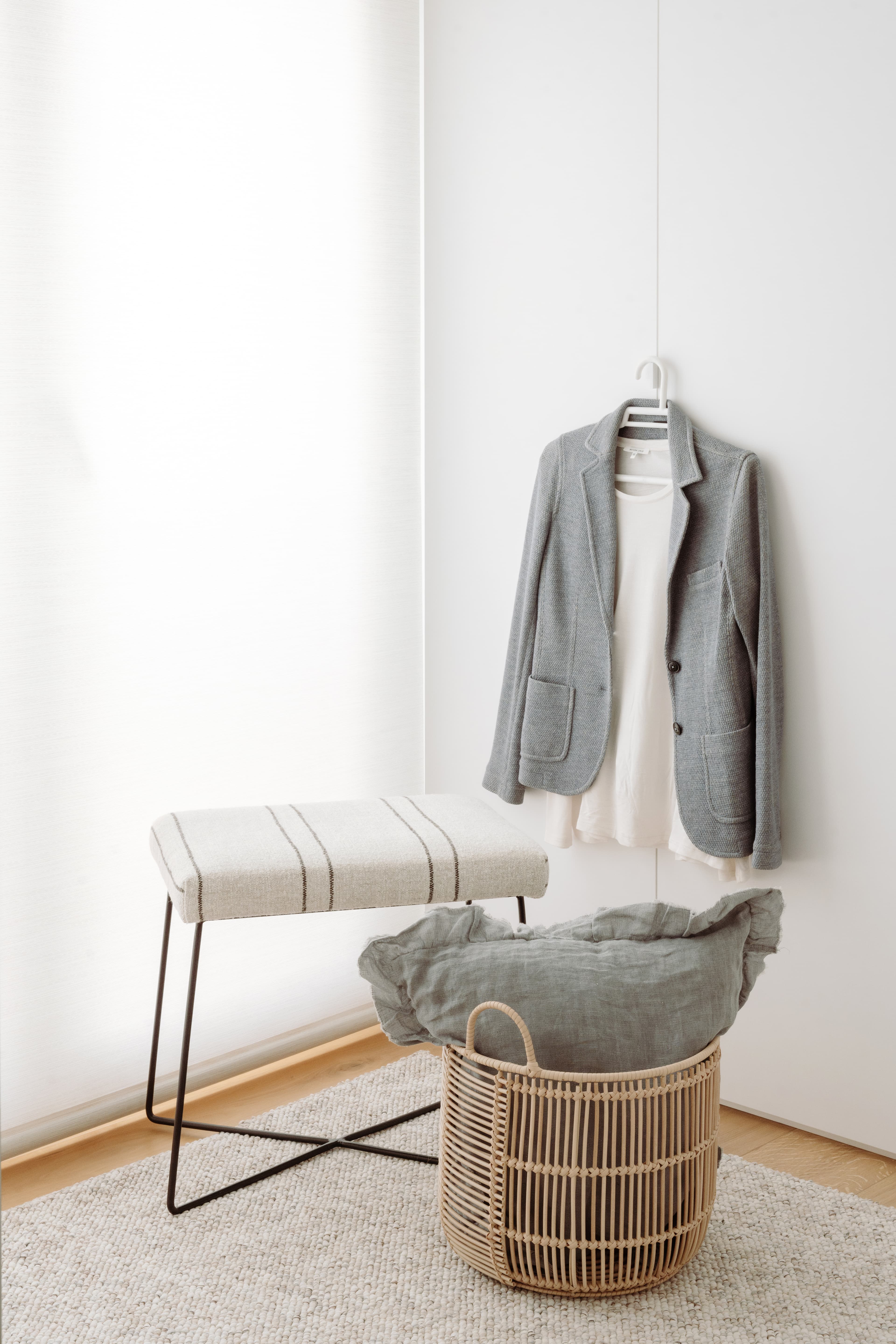 Detalle de un banco y una chaqueta colgada en la puerta del armario