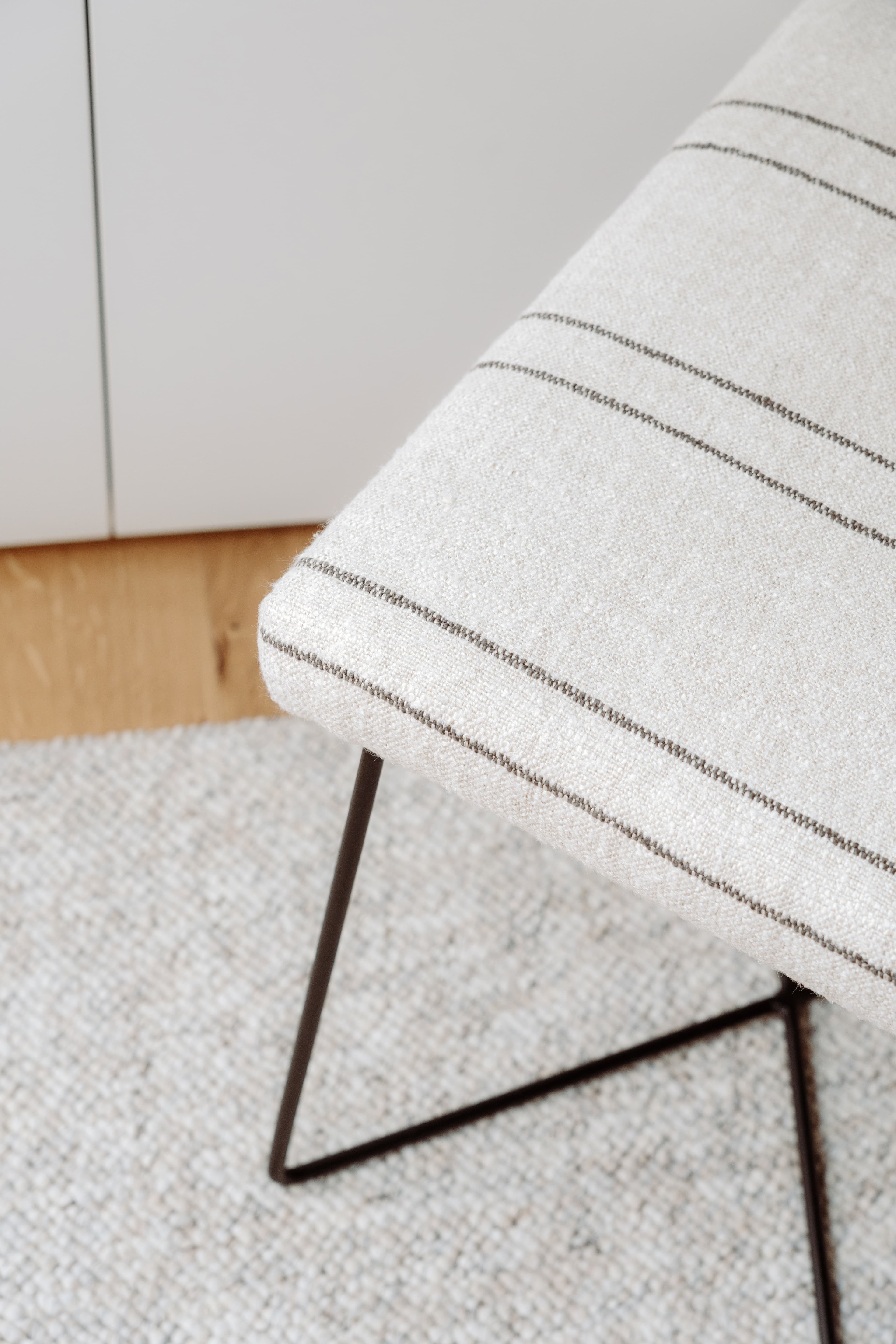 Detalle del banco encima de la alfombra, con el armario de fondo