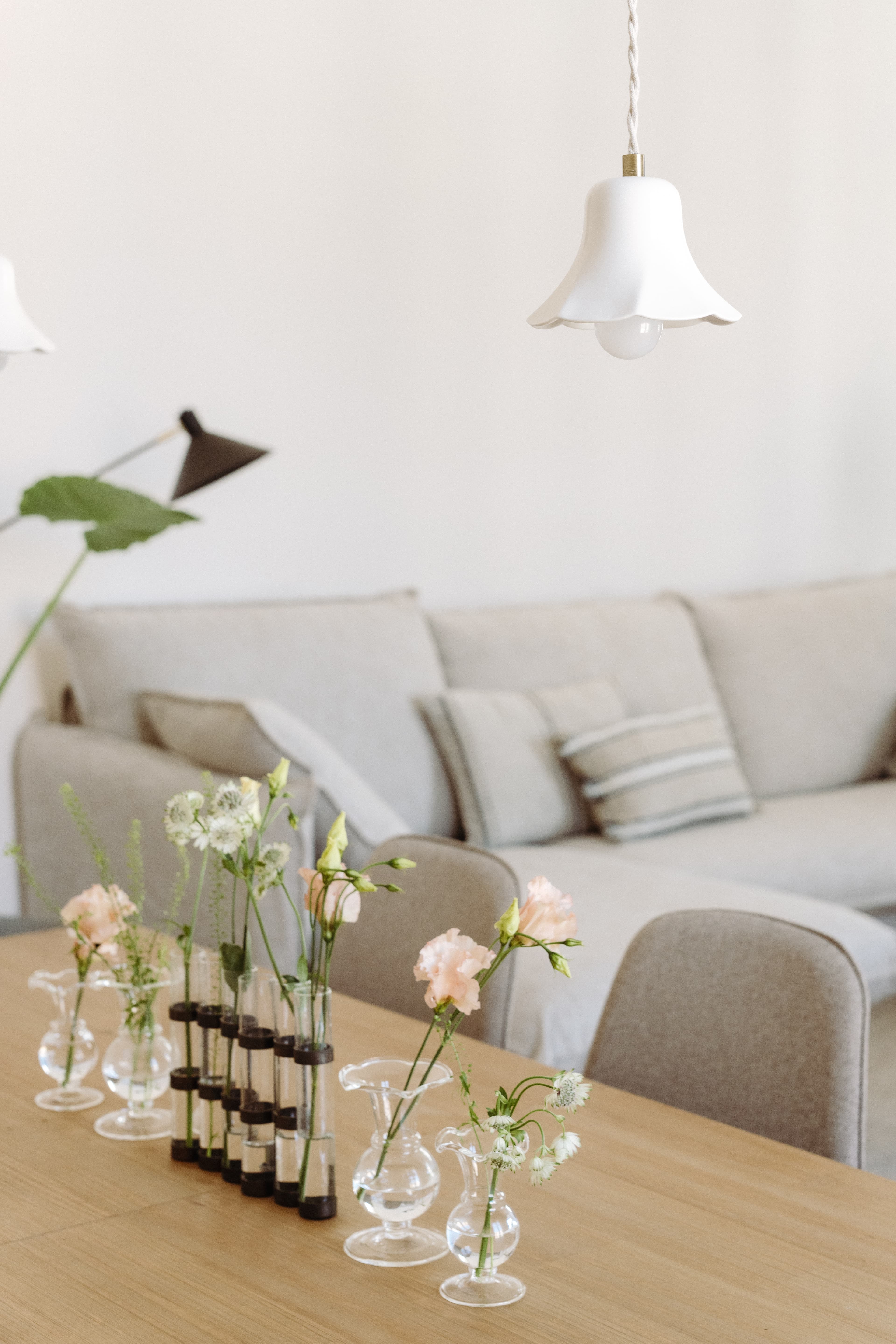 Detalle de las flores sobre la mesa del comedor, con el sofá al fondo