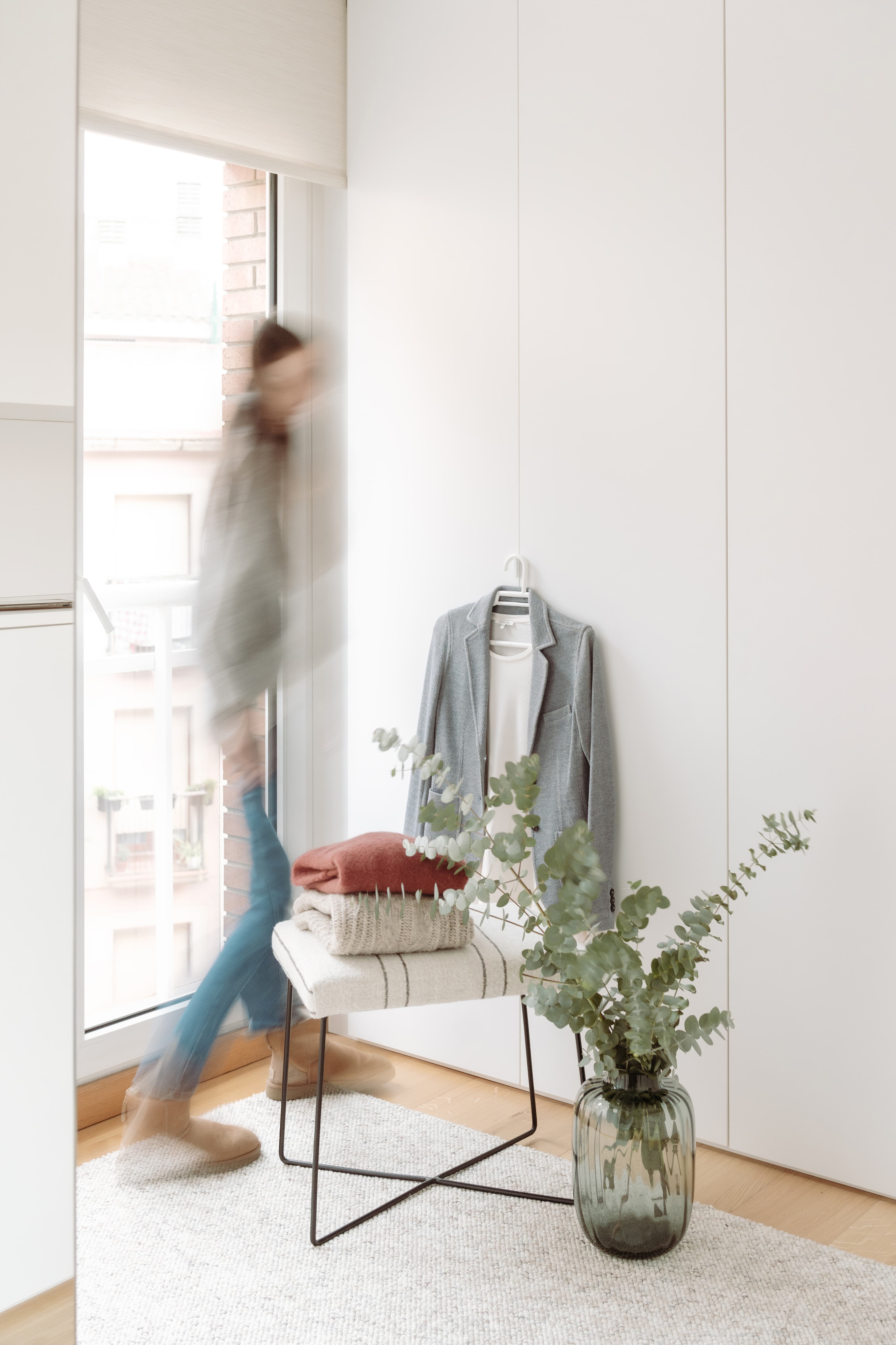 Vista del vestidor con una chica entre el ventanal y el banco