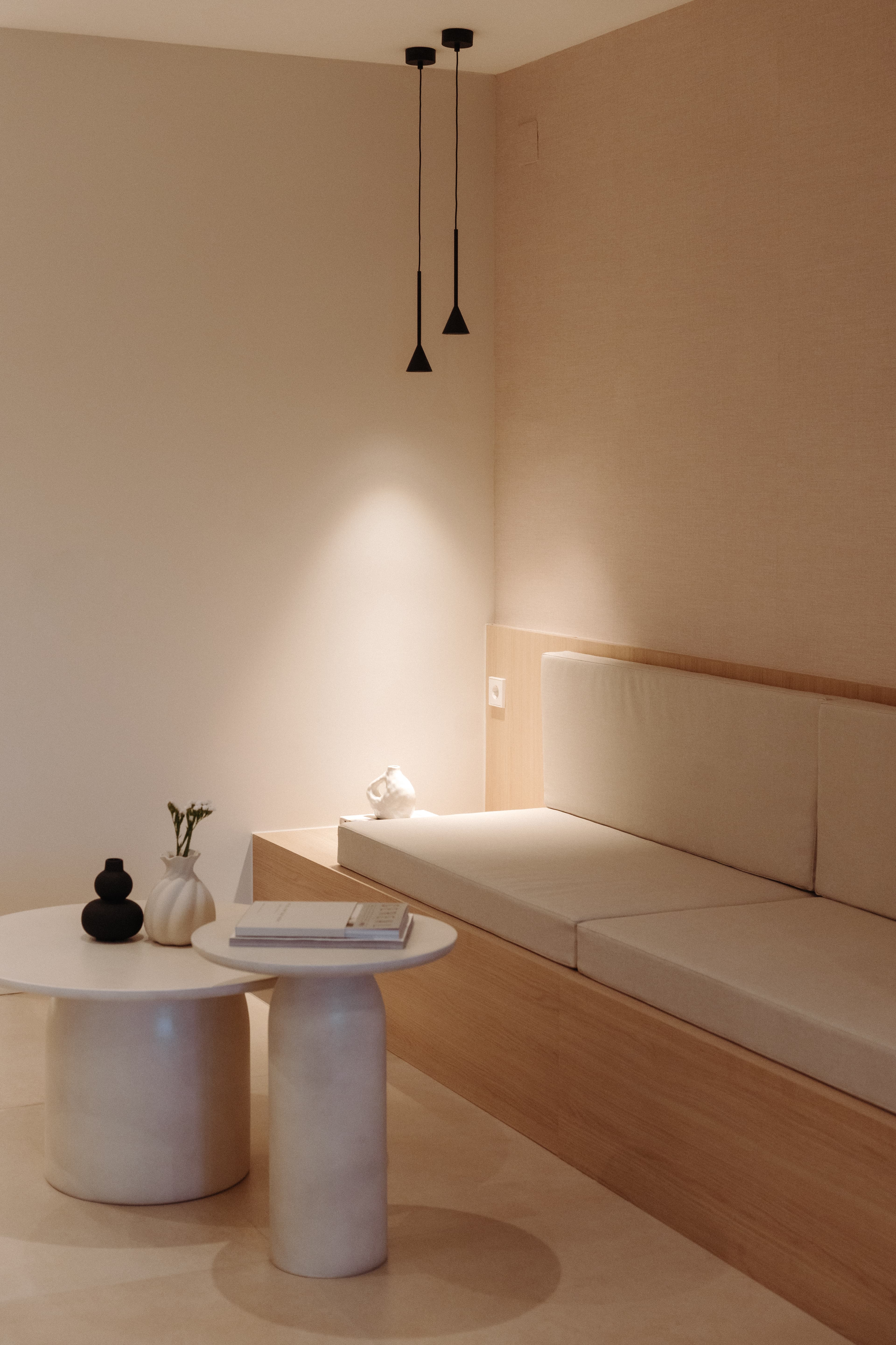 Detalle de un extremo del banco con dos lámparas colgando encima de un jarrón